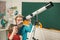 Father teaching son. Pupil watching stars with a teacher and hold Astronomy telescope. Elementary school and education.