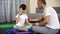 Father teaching son to make dumbbells exercise at home, active childhood, care