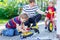 Father teaching two little kid boys to repair chain on bikes