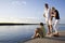 Father and teenage children on dock by water