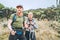 Father and teenage son as Backpackers have hiking walk on the Umbwe route in the forest to Kilimanjaro mountain. Active climbing