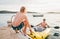 Father with teenager son on the bright yellow inflatable kayak returning back from evening ride by the Adriatic sea harbor in