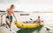 Father with teenager son on the bright yellow inflatable kayak returning back from evening ride by the Adriatic sea harbor in