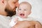 Father tenderly touches his nose to child`s cheek