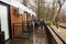 Father with three kids on terrace of one-storey modular houses in spring rainy forest