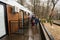 Father with three kids on terrace of one-storey modular houses in spring rainy forest