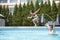 Father throwing daughter into the pool, mid-air