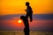 Father throwing his kid up in the air on the beach, silhouette shot