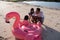 Father and two daughters pumping a flamingo buoy before used to play