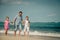 Father and two daughters walking on the beach