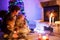 Father and two little toddler boys sitting by chimney, candles and fireplace and looking on fire. Family celebrating