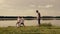 Father and two son playing football on the beach at the day time. Concept of friendly family.