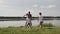 Father and two son playing football on the beach at the day time. Concept of friendly family.