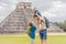 Father and two sons tourists observing the old pyramid and temple of the castle of the Mayan architecture known as