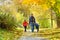 Father and two sons walking in the autumn forest. Back view