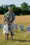 Father in uniform hugging daughter near headstones in graveyard