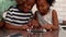 Father using tablet with his children in kitchen