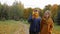 Father walking with daughter in the park in autumn. Dad and teenage smile and laugh and play with beautiful yellow