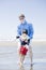 Father walking disabled son at the beach