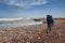 Father walking with his child in a backpack-carrying along the coastline in Malaga by the stormy sea