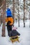 Father walks with his young children in the woods in winter