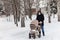 Father walks through the park in winter with a baby carriage, Russia