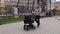 Father walks with the pram walking in the city