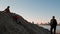 Father watches brother and sister climb sand pile and play