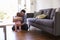 Father Watching Baby Daughter Take First Steps At Home