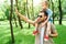 father waving hand to someone and holding son on shoulders