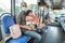 a father wearing a mask sits on a bench holding a cute little baby girl on the bus