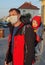 A father wearing a medical protective mask with a baby in a carrier on a street