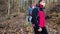 A father wearing a medical protective mask with a baby in a carrier in the woods