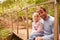 Father and young daughter sitting on a bridge in a forest