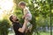 Fatherhood, parenthood, childhood, caring, summer and leisure concept - young dad with beard and long hair in black t