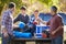 Fathers With Sons Unpacking Truck On Camping Holiday