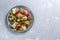Fattoush vegetarian salad in a gray plate on a gray background. Copy space. Top view.