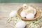 Faux chick sits on eggs in a wicker basket, near eggs lay