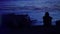 Faux Super 8mm: Silhouetted man rests on cliff next to ocean, contemplating