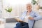 Favorite Pastime. Senior woman relaxing with book and hot tea at home