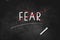 FEAR  Crossed out word with a red line   written with chalk on blackboard icon logo design vector illustration