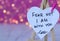 Fear not, I am with you, handwritten text verse on heart-shaped note with blurred bokeh background