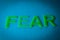 Fear. Word made by green letters on blue background.