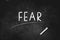 FEAR  written with chalk on blackboard icon logo design vector illustration