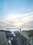 Fearless man with a backpack watching the sunset over the Atlantic Ocean in Porto Covo, Portugal