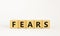 Fears symbol. The concept word `fears` on wooden cubes. Beautiful white table, white background, copy space. Business,