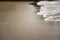 Feather and soft wave of ocean on the sandy beach