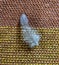 Feather standing alone on an ocher and brown woven rug.Selective focus.