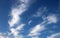 Feathery white clouds in clear blue sky