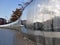 Feature tall water wall of bright steel by path leading to railway station in Sheffield